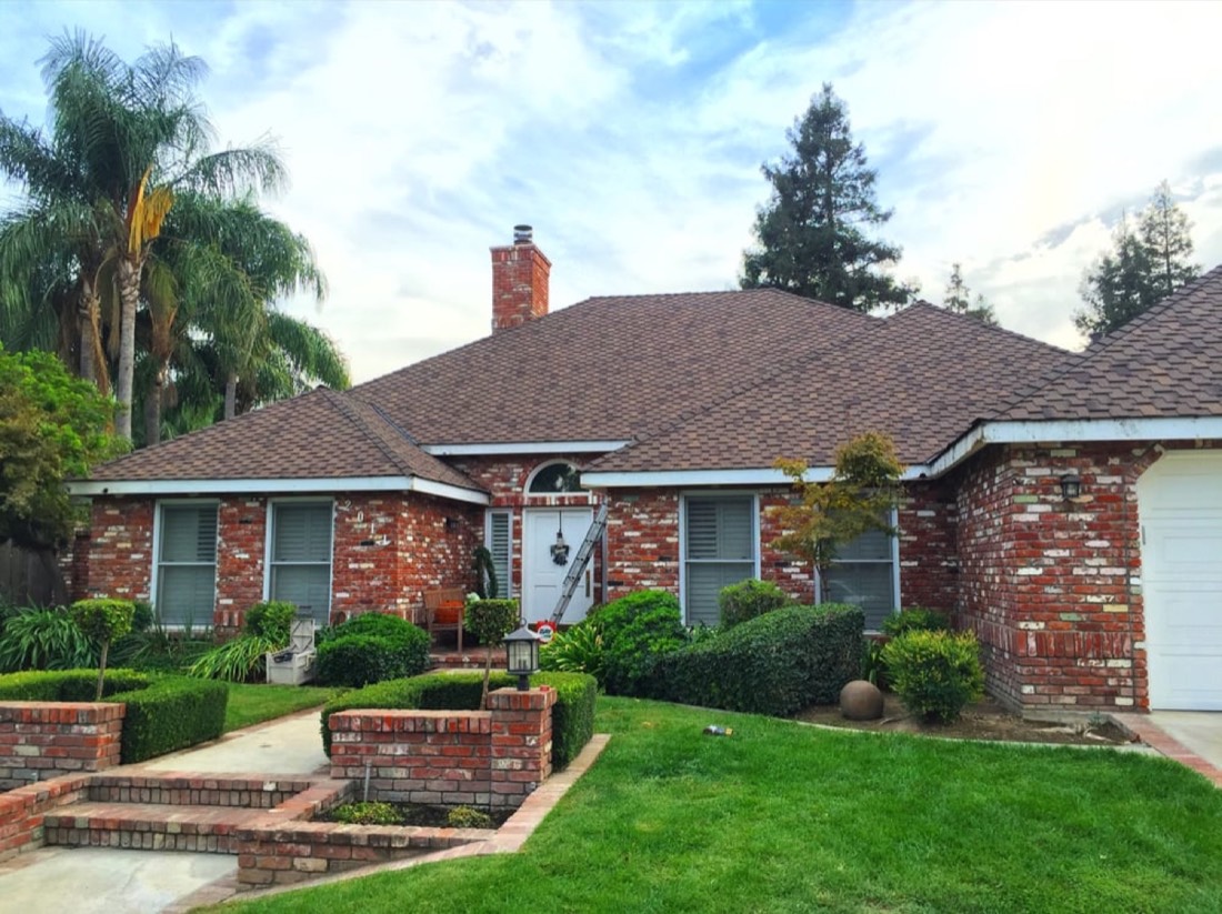 Brick ranch home in Modesto with new architectural shingles — typical Central Valley roof replacement pricing reference