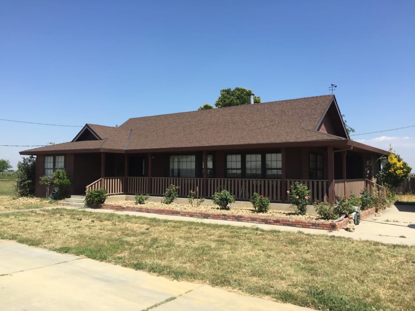 Rural Hilmar farmhouse with architectural asphalt shingles installed by DeHart Roofing — common comparison vs. standing seam metal