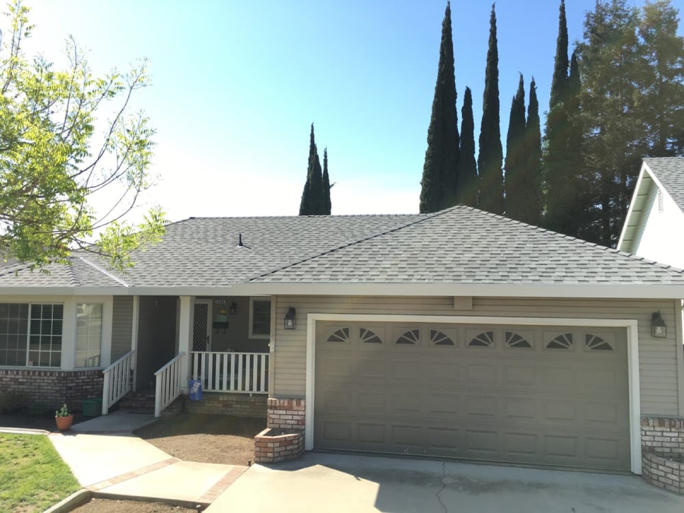 Modern Modesto suburban home with new architectural shingles and decorative garage doors — HOA replacement reference