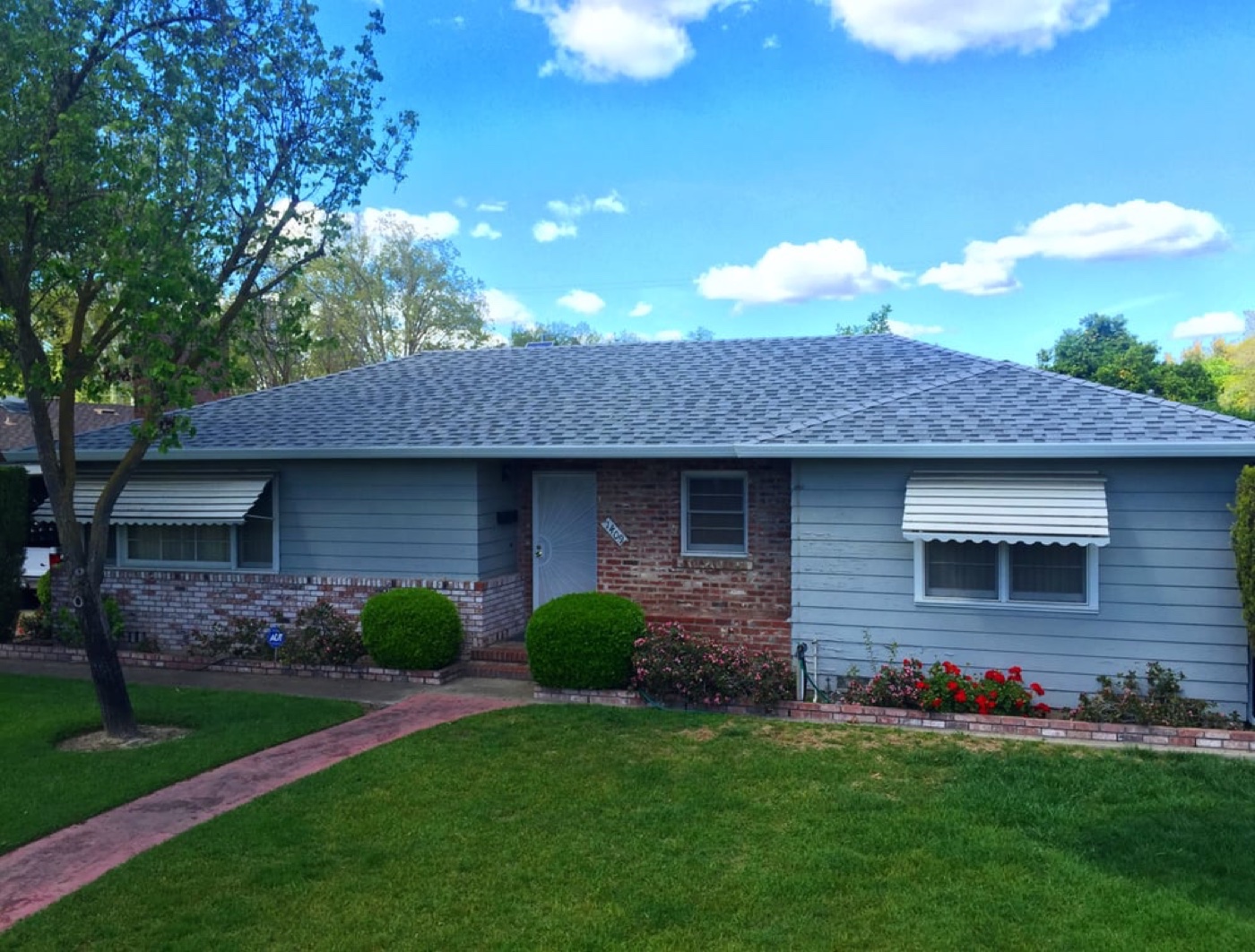 Single-story Central Valley home with new gray architectural shingles and gutters installed by DeHart Roofing