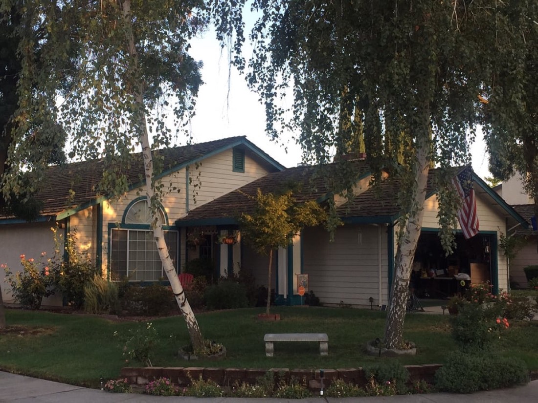 Turlock family ranch home at twilight after a completed DeHart Roofing maintenance and shingle replacement