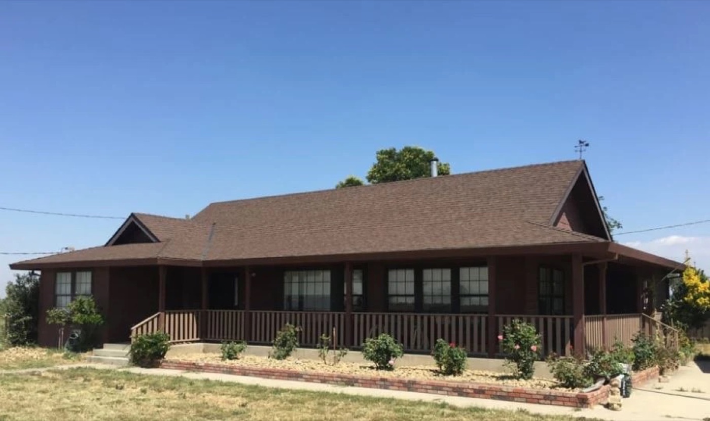 Rural Central Valley farmhouse with completed shingle roof — financing reference for working families