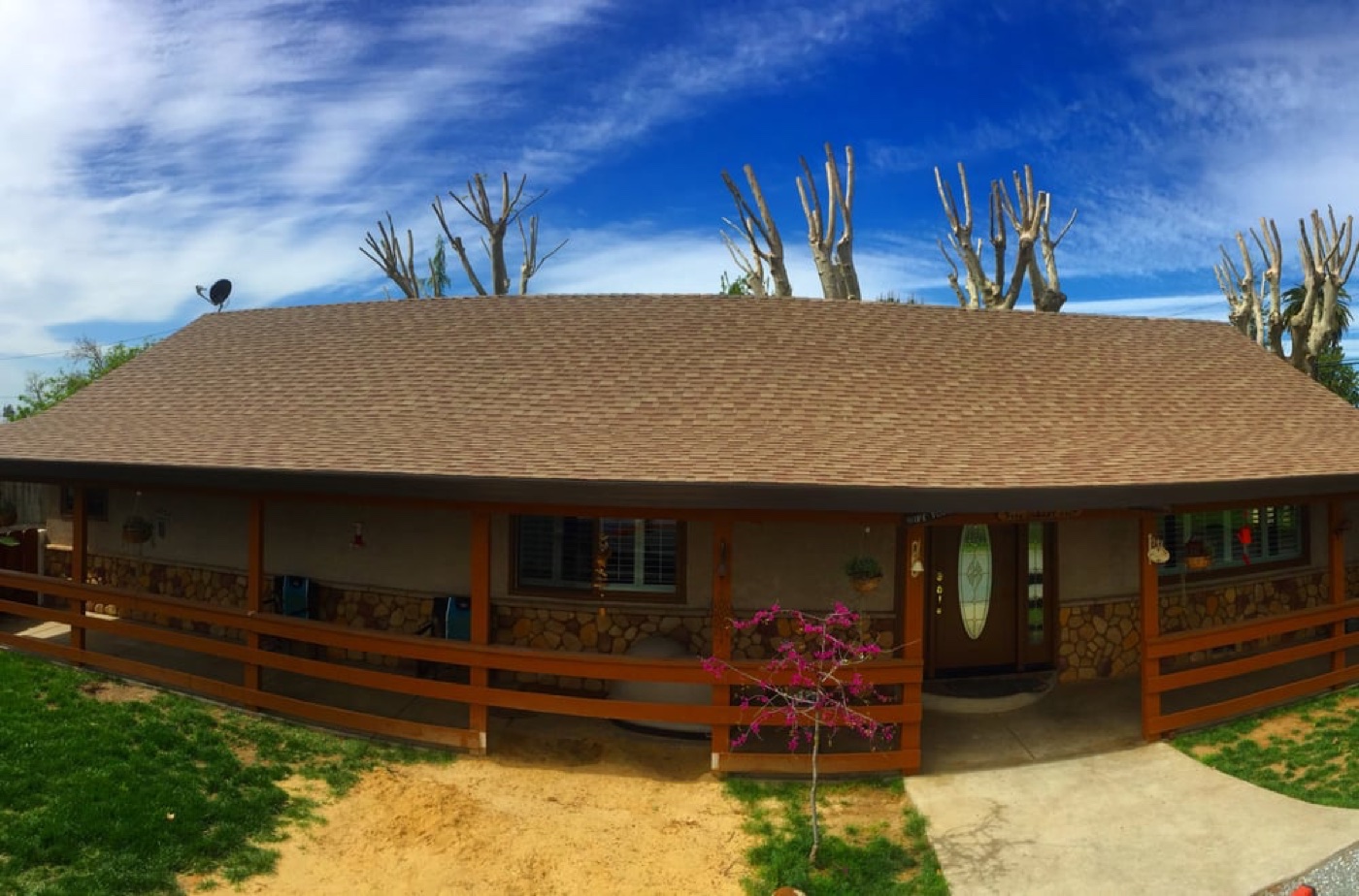 Wide Central Valley ranch home with stone porch posts and new architectural shingles — California roof permit reference