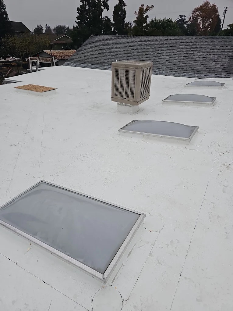White TPO commercial roof with skylights, installed by DeHart Roofing in the Central Valley