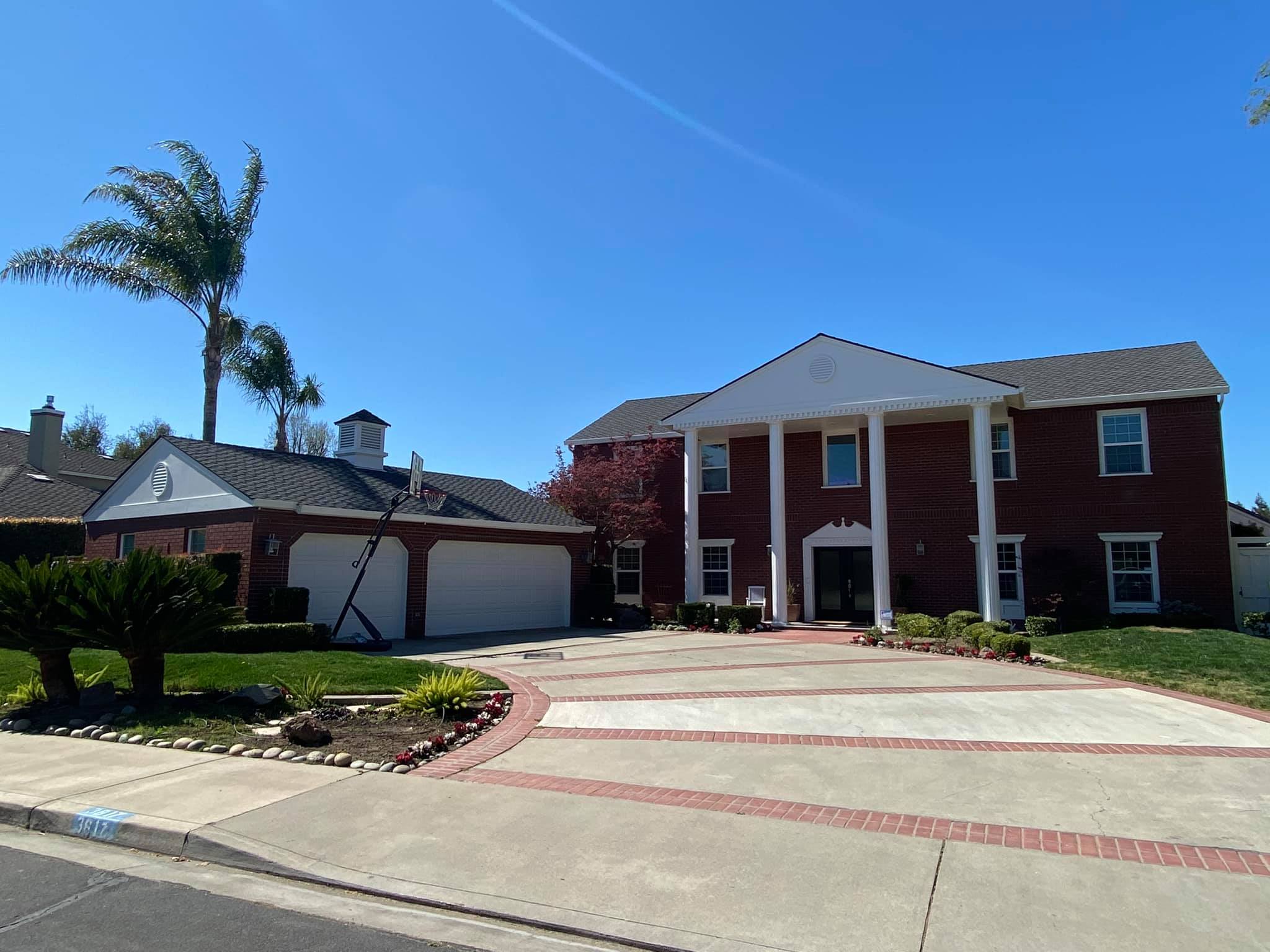 Completed roof replacement on a colonial brick home in Turlock